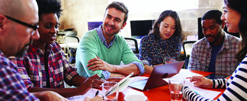 Group Of Designers Having Meeting Around Table In Office