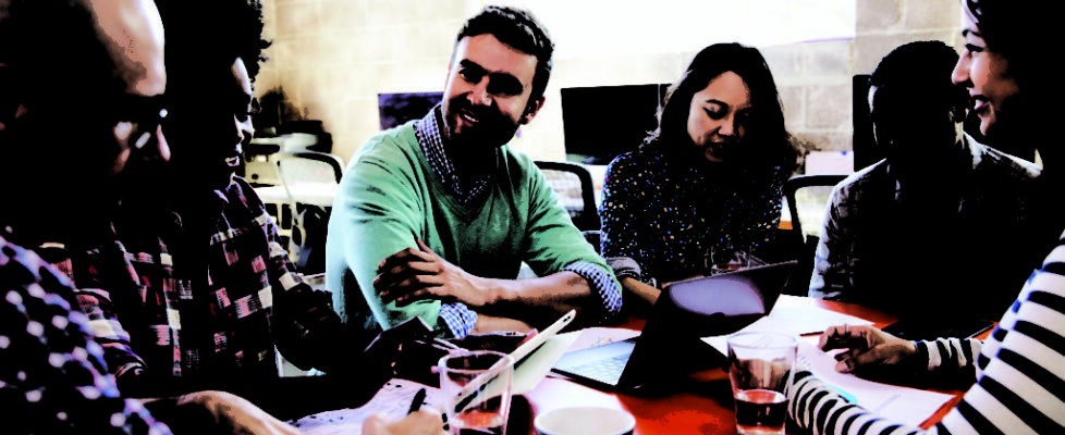 Group Of Designers Having Meeting Around Table In Office